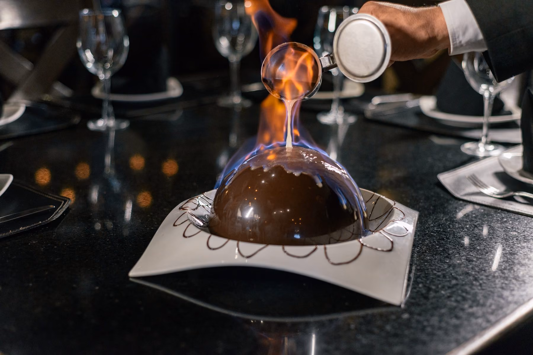 Postre de chocolate en forma de esfera con relleno visible